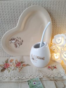 Mate de cerámica, con platito a juego. Debajo, un mantel individual, en lienzo de algodón. Todo estampado con transfers.