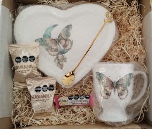 Box de regalo con jarrito para chocolatada, con platito forma de corazon, cuchara de diseño dorada, alfajores havanna y barrita aguila