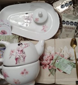 Box de regalo con set de té con flores de sakura, tipo oriental. Contiene tetera, tazon, bandeja ovalada, mantelito de lienzo de algodon, cuchara de diseño dorada, y alfajores havanna.